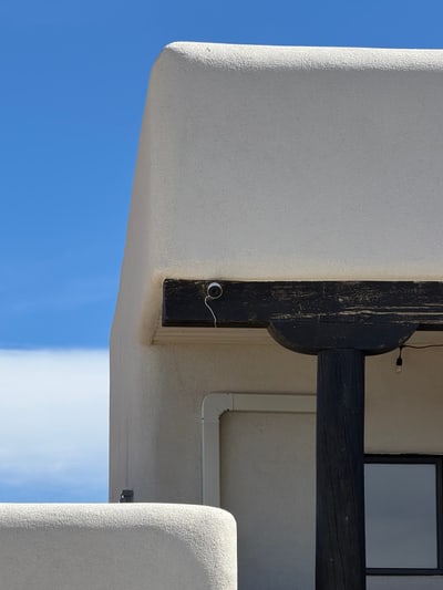 Professionally installed outdoor security camera beneath a Santa Fe home eave